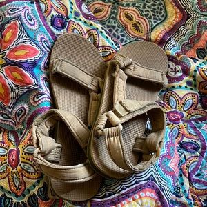 A pair of tan beach sandals, very adjustable in with size.